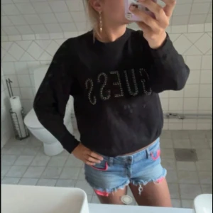Svart tröja med strass från Guess - Svart långärmad tröja från Guess med stor logga framtill dekorerad med glitterpaljett liknande. Tröjan har rund halsringning och är i mjukt material, perfekt för dig som gillar en clean men ändå glittrig look. Den är jätte skön i princip nyskick då jag inte använt den mer än 5 ggr💓💓