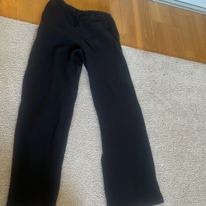 Svarta mjukisbyxor med snörning - Svarta mjukisbyxor med rak passform och elastisk midja med snörning. Byxorna har en lätt skrynklig textur och är perfekta för en chill och avslappnad stil. Passar dig som gillar bekväma och stilrena plagg. Så sköna mjukis byxor. Andvänt 3 gånger.