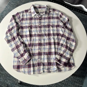 Rutig skjorta från Beauty & Youth - Riktigt snygg rutig skjorta från Beauty & Youth United Arrows i vitt, blått och rött. Skjortan har klassisk krage, två bröstfickor med knappar och långa ärmar. Perfekt för dig som gillar en avslappnad men ändå stilren look.