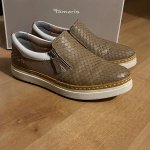 Sneakers från Tamaris  - Supersköna och lätta sneakers från Tamaris. I toppskick och endast använda ett fåtal gånger. Ordinarie pris är 899kr och säljes med originalkartongen! 