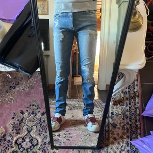 Ljusblå slitna slim jeans från Jack and Jones 32/34 - Säljer ett par ljusblå skinny jeans med slitningar och trasiga detaljer på låren och knäna. Jeansen har klassisk femficksdesign och sitter tight längs benen. Perfekta för dig som gillar en trendig och avslappnad look. Modellen är 178 70kg midja 40 längd 104cm (13)