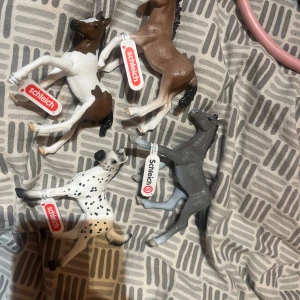 SleIch hästar - Bilden visar fyra Schleich-djurfigurer, främst hästar och en dalmatiner. Figurerna är detaljerade och i gott skick, perfekta för samlare eller barn. Inga synliga defekter eller slitage. Ej elektronik.