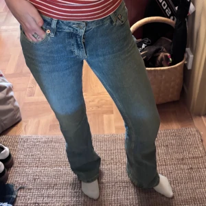 blå lågmidjade bootcut jeans - Nypris:700kr. Mycket bra skick. Pris kan diskuteras. Säljer ett par lågmidjade jeans i ljusblå denim. De har bootcut passform, detaljer på bakfickorna med blixtformad söm. 