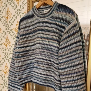 Randig stickad tröja Carin Wester M - Säljer en randig stickad tröja från Carin Wester i blå, grå och beige toner. Tröjan har en loose passform, rund halsringning och långa ärmar. Perfekt för lager-på-lager och chill höst- eller vinterstil. Ny med lapp, inga anmärkningar.