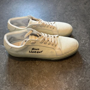 Saint Laurent vita sneakers  - Vita saint Laurent  använda Vita Saint Laurent-skor i mycket gott skick. Använda sparsamt under cirka ett år med minimala tecken på slitage. Originalbox medföljer ej.