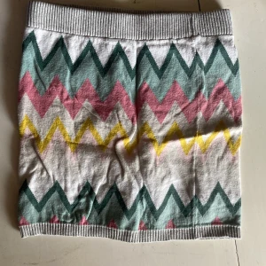 Mönstrad kortkjol från H&M, bomull - Superfin kortkjol från H&M i mjuk bomull med färgglada sicksackmönster i grönt, rosa, gult och vitt. Kjolen har bred ribbad midja och är perfekt för dig som gillar lekfull stil och bekväma plagg.