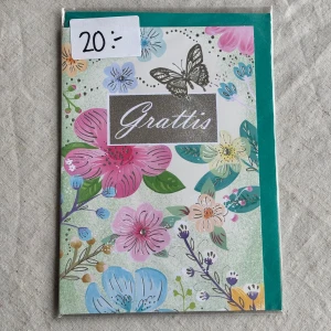 Gratulationskort  - Färgglatt gratulationskort med blommor och fjäril, perfekt för att fira någon speciell. Medföljer kuvert samt den är kvar i sin ursprungliga förpackning. Insidan består av helt vita blad så plats för mycket text 