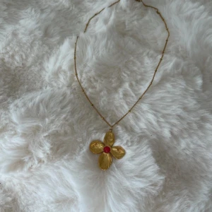blom halsband  - säljer ett gulligt blom halsband i rostfritt stål. köpte den i spanien! skriv om ni har frågor!