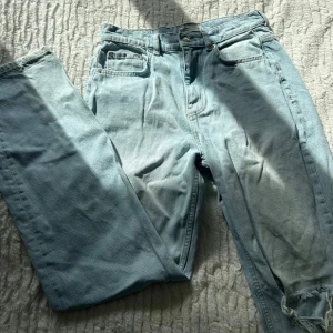 Ljusblå ripped jeans från Perfect Jeans - Ljusblå jeans från Perfect Jeans i storlek 36. Modellen har raka ben och slitna detaljer med stora hål vid knäna för en cool, avslappnad look. Klassisk femficksdesign och knappgylf. Perfekta för dig som gillar streetstyle.