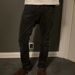 Svarta jeans från Emporio Armani - Snygga svarta jeans från Emporio Armani med klassisk femficksdesign och diskret logga på myntfickan. Jeansen har en rak passform och är tillverkade i mjukt denimtyg som sitter skönt hela dagen. Perfekta för dig som gillar stilrena och tidlösa plagg.