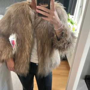 Beige pälsjacka - Säljer en fluffig och trendig beige pälsjacka, små bitar av nedre kanten på insidan kan lossna och smula lite, se bild! annars jättefint skick, storlek M men skulle mer säga S. Har bara två knappar längst upp som man kan knäppa! Perfekt för dig som vill sticka ut och hålla dig varm med stil.