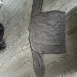 Ribbad grå stickad tröja - Mysig ribbad stickad tröja i grått med lång ärm och rund hals. Perfekt för lager-på-lager och chill dagar. Enkel och stilren design som passar till det mesta.