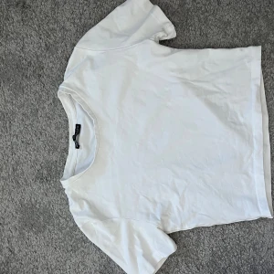 Vit basic t-shirt från Zara - En klassisk vit t-shirt från Zara i storlek S. T-shirten har rund halsringning och korta ärmar, perfekt för en clean och enkel stil. Tillverkad i mjuk bomull som känns skön mot huden.