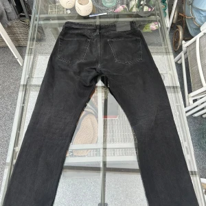 Jack & Jones Chris Loose Fit Jeans – Svart (W31 L32) - Supersnygga Jack & Jones Chris Loose Fit Jeans i färgen svart / washed black. Modellen Chris har den där avslappnade, raka passformen som sitter löst och bekvämt – perfekt för en casual streetstyle-look eller till vardags. Kommer från Jeans Intelligence-kollektionen och är i riktigt fint skick utan hål, fläckar eller slitningar.  📏 Storlek: W31 L32 🎨 Färg: Svart / washed black 👖 Passform: Loose fit (Chris) 🧵 Material: 99 % bomull, 1 % elastan – mjukt och lite stretchigt 💎 Skick: Mycket bra skick