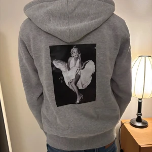 Grå hoodie med Marilyn Monroe-tryck - Säljer denna riktigt fet grå Zenito med dragkedja och huva. Storlek: S! Passa dig perfekt runt 170-178! Skick:8/10  priset är ej hugget i sten! Fraktar snabbast med PostNord!!