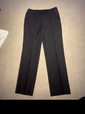 Svarta smokingbyxor! Nyskick! - Eleganta svarta smokingbyxor från Tiger of Sweden i nyskick. Klassisk och stilren modell som passar perfekt till fest, bal eller andra formella tillfällen.  📏 Mått (platt mätt): 	•	Midja: 43 cm 	•	Innerben: 80 cm 	•	Ytterben: 107 cm  💰 Nypris: ca 2 500 kr  Byxorna är mycket sparsamt använda och i utmärkt skick, utan slitningar eller fläckar. Skicka gärna meddelande vid frågor eller om du vill ha fler bilder!