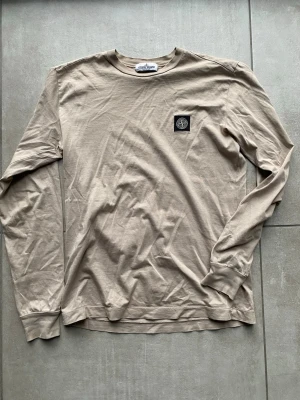 långärmad tröja Stone Island - Säljer en beige långärmad tröja från Stone Island med klassisk patch på bröstet. Den är helt oanvänd, pris kan diskuteras. 