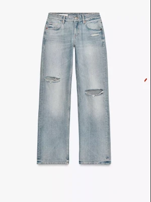 Jeans trf wide leg låg midja med revor - Säljer ett par slutsålda jätte snygga vida ljusblå jeans med breda ben och slitna detaljer vid knäna. Köpte två olika storlekar och behåller en, därför säljer därför jeansen i 38. Jeansen är från Zara! ❣️❣️