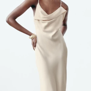 Beige satin klänning med öppen rygg - Säljer denna fina festklänning från Zara i storlek XS, den är använd vid ett enda tillfälle så den är i mycket bra skick. Priset kan diskuteras✨