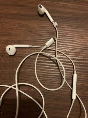 Äkta apple hörlurar  - Säljer ett par Apple EarPods med Lightning-kontakt. Hörlurarna har inbyggd  mikrofon. Passar iPhone-modeller utan hörlursuttag. Fint skick då de är som helt nya. Perfekt för samtal och musik.