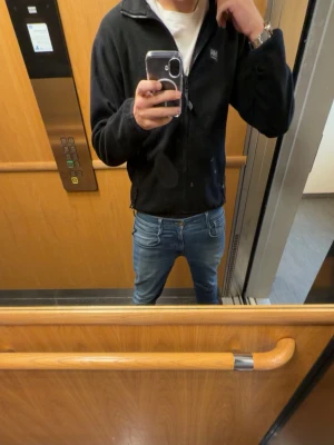 Svart fleecejacka Helly Hansen - Säljer en tvär fett svart fleecejacka från helly Hansen med klassisk logga på bröstet. Perfekt under jacka eller över tröja för vinter och vår. Pris ej hugget i sten. Vid fler frågor och funderingar är det bara att höra av sig