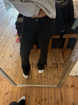 Svarta bootcut jeans - Säljer ett par svarta jeans med bootcut passform och klassisk femficksdesign. Jeansen har normal midja och är tillverkade i ett mjukt jeansmaterial med stretch. 