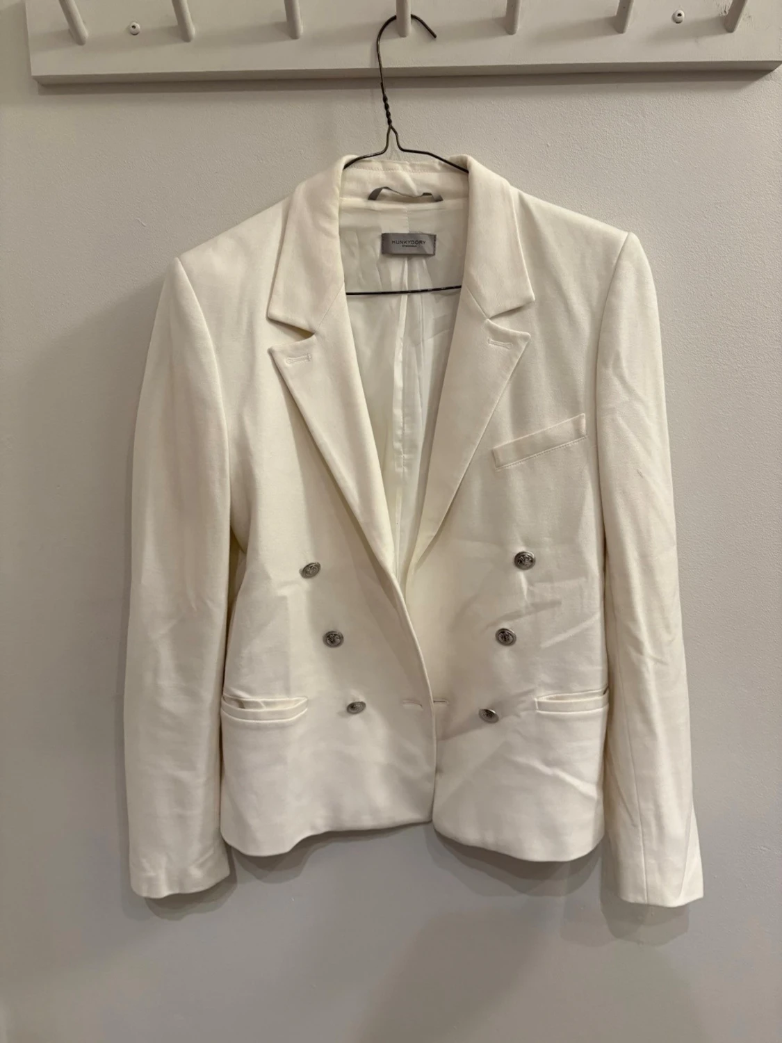 Vit kavaj med silvriga knappar