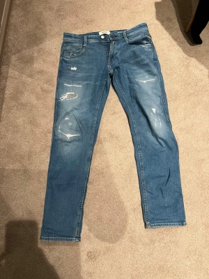 Ljusblåa Replay jeans  - Ett par ljusblåa Replay jeans som är i bra skicka, det ända är det lilla hålet som du kan se på bild tre men din inte särkilt mycket när man har på dem. Ny pris 1800kr säljer för 600kr men kan gå ner i pris vid snabb affär. Skicka om du har någon fråga