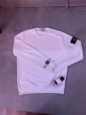 Vit sweatshirt från Stone Island - Säljer en stilren vit sweatshirt från Stone Island. Den är i storlek L och har endast använts ett fåtal gånger! Det finns inge tecken på användning! Hör av er vid minsta fråga!