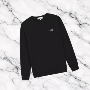 Svart Lacoste Tröja - Svart Lacoste tröja med liten logga vid bröstet.