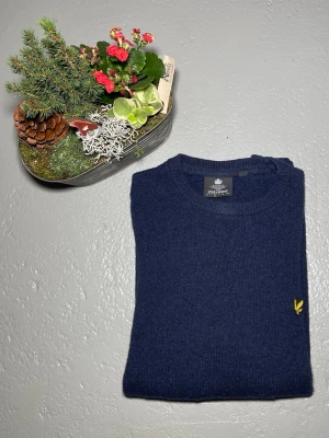 Mörkblå stickad tröja Lyle & Scott - Mörkblå stickad tröja från Lyle & Scott med rund halsringning.                                                  Storlek M                                                                  Skriv vid frågor!!! 