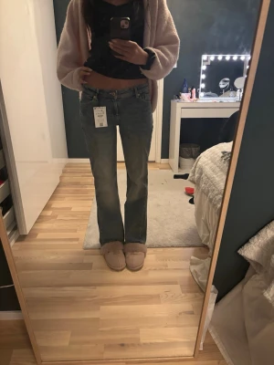 bootcut jeans blå - Snygga blå jeans med klassisk bootcut-passform. Jeansen har en normal midja och raka ben som blir lite utsvängda nertill. 