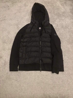 Svart canada goose cardigan, storlek L - Hej! Säljer en svart Canada Goose cardigan i storlek L. Den är i mycket bra skick och allt og medföljer✅. Nypris på denna cardigan är runt 7500. Skriv vid minsta fråga eller funderingar!
