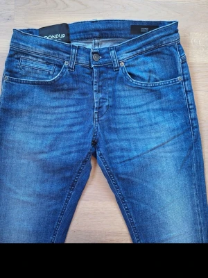 Dondup skinny jeans blå 29 - Snygga blå jeans från DONDUP modellen George. Storlek 29. Femficksmodell. Ljus tvätt. Small passform. Mjuk demin tyg med stretch. Låg midja. Knappgylf. Tillverkade i Italien. Mycket bra skick. 