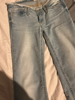 Nelly jeans  - Ljusblå low waist Nelly jeans med frans runt midjan. De är i storlek 34 men jag har använda stryk klister för att vika upp de där nere, det är enkelt att får bort. De är använd några gånger och är i jättebra skick. 