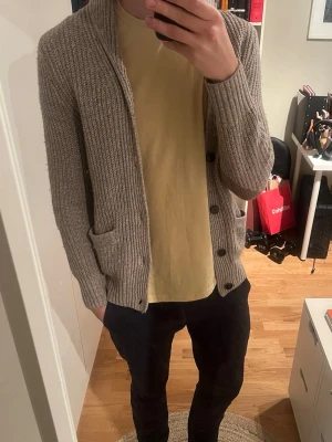 Beige stickad kofta från H&M - Säljer en beige stickad kofta från H&M i ullblandning. Sjukt snygg!