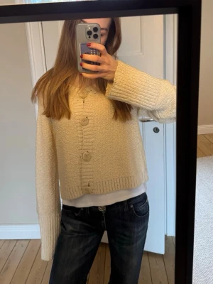 Beige stickad kofta med stora knappar - Säljer en beige stickad kofta med stora, matchande knappar framtill. Jättefin och väldigt snygg passform. Passar mig som är S/M vanligtvis. 