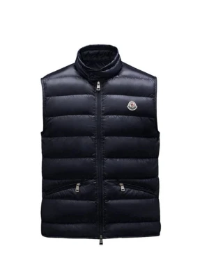 Mörkblå dunväst från Moncler - Säljer en svart dunväst från Moncler med hög krage och två praktiska fickor med dragkedja. Västen har ett quiltat mönster och Moncler-loggan på bröstet. Perfekt att slänga över en hoodie för extra värme.