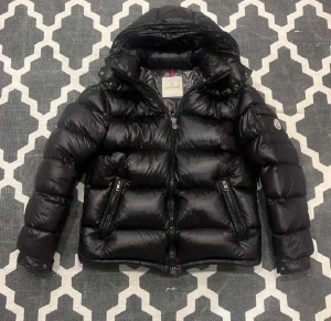 Svart pufferjacka från Moncler - Säljer en svart pufferjacka från Moncler med glansig finish och huva. Jackan har dragkedja framtill, två sidofickor med dragkedja och Moncler-logga på ärmen. Materialet är polyester och dun, perfekt för kalla dagar. Stilsäker och riktigt fet jacka för vintern.