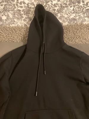 Svart Jack & Jones Hoodie - Säljer min svarta hoodie från Jack & Jones. Den är i mycket bra skick och knappt använd. Perfekt för den som gillar streetwear eller bekväm stil.