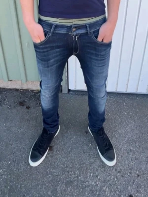 Replay jeans  - Säljer ett par snygga Replay jeans i mörkblå tvätt med skinny passform. Jeansen har klassiska fem fickor, dragkedja och knapp framtill samt coola detaljer på bakfickorna. Perfekt för dig som gillar en smal siluett och streetstil.