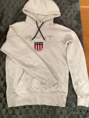 GANT Hoddie  - Den är sliten, men med lite sy tråd för man den till ett nytt stadie igen. 