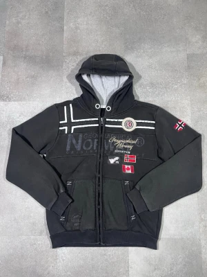 Vintage Geographical norway zip up hoodie - Säljer en vintage Y2K Geographical Norway zip-up hoodie i snygg svart färg. 🧵 Märke: Geographical Norway 👕 Storlek: XL (motsvarar mer L, se bilder/mått) 🎨 Färg: Svart 📌 Design: Zip-up hoodie i klassisk Y2K-stil 📍 Skick: Mycket bra, se bilder!  Beskrivning: • Äkta Y2K-design från Geographical Norway • Zip-up modell med huva – praktisk och stilren • Bekväm och varm, perfekt för vardag och lager-på-lager • Inga fläckar, noppor eller skador (kontrollera bilder) • Lätt att matcha med jeans, cargos el