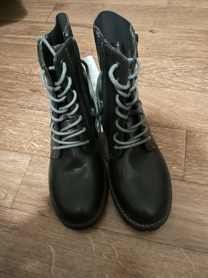Svarta boots från Walkx, storlek 39  - Jättefina boots, tyvärr passade de ej mig.  Storlek 39, aldrig använda. (De ser svarta ut på bild men är mer svartbruna med gråa snöre)  Det är två dragkedjor på vardera sida, men endast en man använder. 