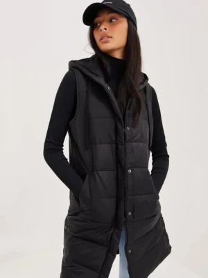 DEA-VEST från Nelly - Snygg svart lång dunväst med huva och knappar framtill. Västen är quiltad och har en stilren look som passar perfekt över en hoodie eller tröja. Praktiska fickor på sidorna och en rak passform gör den både bekväm och trendig.