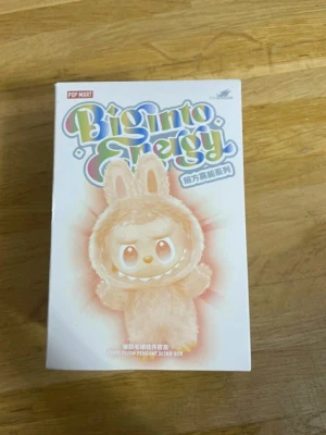 Beige pälsväst från Pop Mart - Säljer en beige pälsväst inspirerad av kanin från Pop Mart. Västen har en fluffig look med öron på huvan och är gjord i syntetiskt pälsmaterial. Perfekt för dig som gillar gulliga och unika plagg med en lekfull vibe.