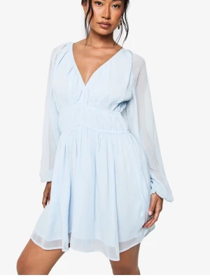 Ljusblå kortklänning från Boohoo - Supersöt ljusblå klänning från Boohoo med v-ringad hals och långa ärmar. Klänningen har snygga rynkade detaljer vid midjan och ett flowigt tyg som ger en luftig känsla. Perfekt för dig som gillar en feminin och trendig look.