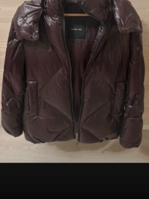  pufferjacka från Massimo Dutti - Säljer en vinröd pufferjacka från Massimo Dutti i storlek M. Jackan har glansig yta, hög krage och dragkedja framtill. Fylld för extra värme och har två stora fickor på sidorna. Perfekt för kalla dagar och riktigt snygg till streetwear. Skriv privat för fler bilder💕
