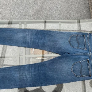 👖 Lee Jeans – Daren Zip Fly (W33 L32) - Snygga och tidlösa jeans från Lee i modellen Daren Zip Fly. Klassisk rak passform med dragkedja, mellanmörk blå tvätt och lätt slitna detaljer framtill som ger en cool och trendig look.  📏 Storlek: W33 L32 🎨 Färg: Blå denim, lätt tvättade 📌 Modell: Daren Zip Fly – regular fit/straight 🧵 Material: 100 % bomull ✨ Detaljer: Slitningar på framsida lår, klassisk Lee-bakficka, läderpatch bak med logga.  Perfekta vardagsjeansen som funkar lika bra till en t-shirt som till skjorta – både stilrena och be