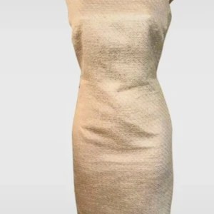 Glittrig kortklänning från L.K. Bennett - Supersnygg glittrig kortklänning från L.K. Bennett i ljusa toner med inslag av silver och små gula detaljer. Klänningen har en figurnära passform, är ärmlös och har en slits bak. Materialet är polyesterblandning med glittrig finish, perfekt för dig som vill sticka ut.